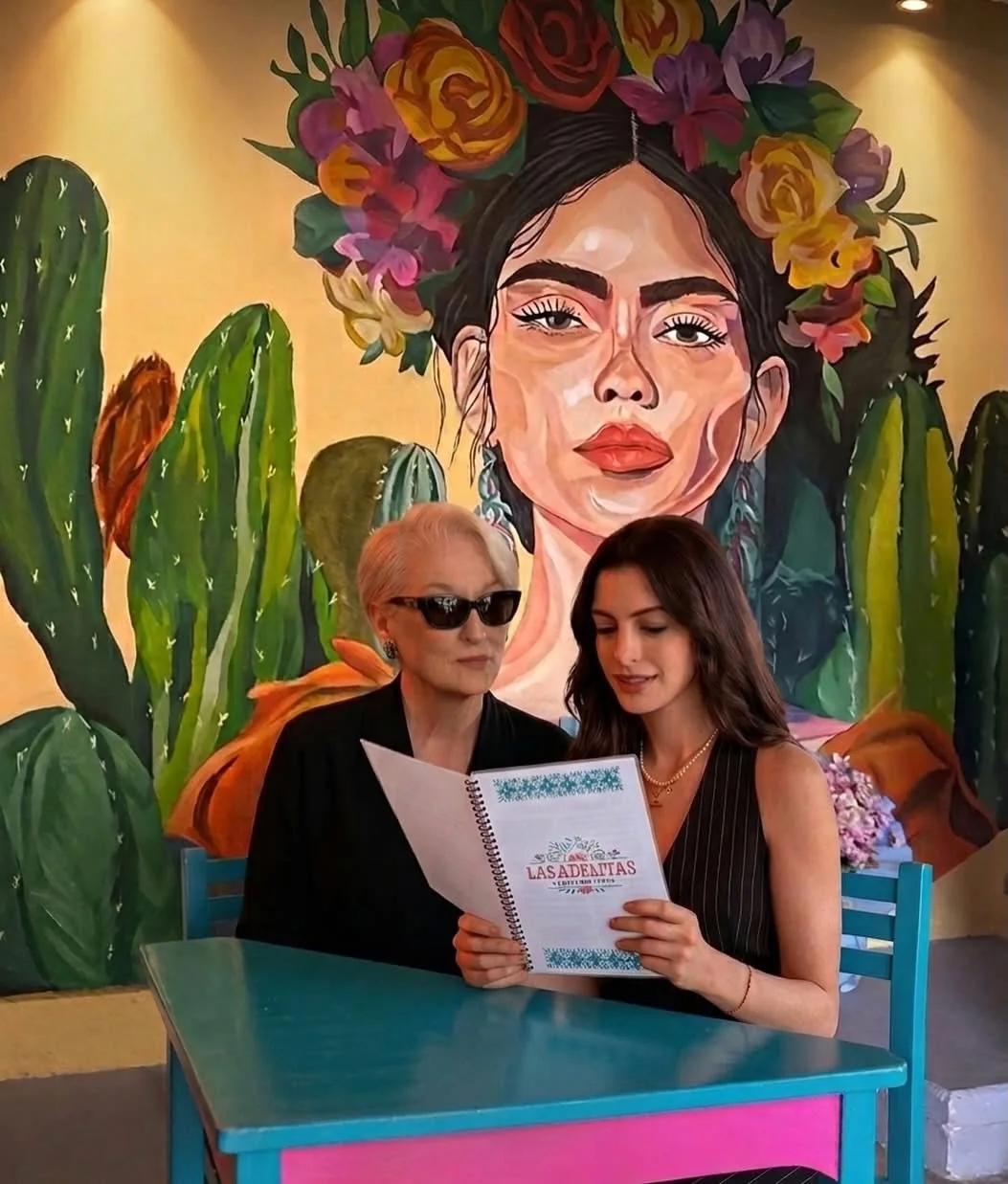 Mural mexicano y comensales en Las Adelitas